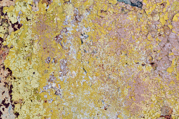 The surface of the concrete wall with cracked and detached oil paint. Cracks cover the entire surface. The paint was applied in several layers. Layers of different colors. Background, backdrop.