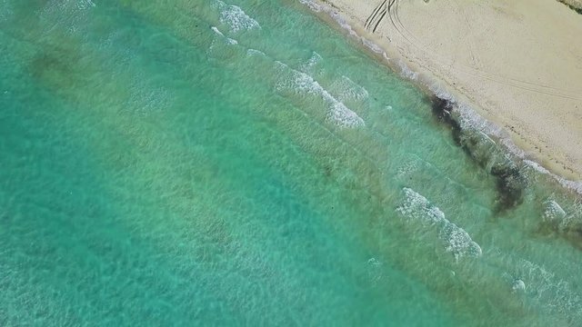 4k hd aerial bird look drone shot in slow motion, waves going and coming , golden sandy beach, in Ilıca, Cesme, Izmir Province, Turkey