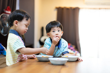 The brothers are enjoying their favorite omelet before going to school.