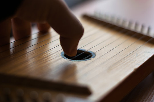 Ukrainian string instrument. Hand playing on dulcimer strings