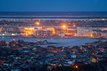 Yakutsk, Yakutia/Russia-April 14 2019: Aerial view of Yakutsk skyline with Beloe lake in beautiful post sunset twilight during blue hour at dusk with clear blue sky in cold spring