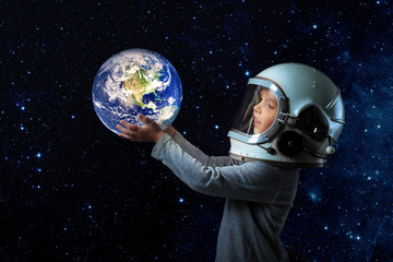 a small child imagines himself to be an astronaut in an astronaut's helmet. 