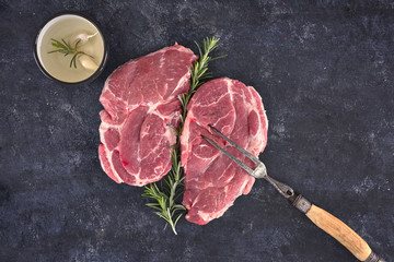 Raw meat steak on dark background. Copy space text concept. Fresh rosemary.