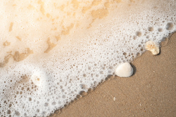 sea wave with bubbles on the sand beach