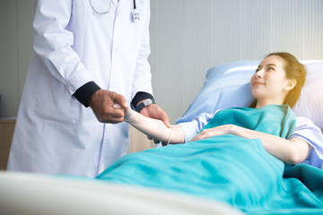 Fototapeta premium Doctor giving a consultation and encouragement to patient together,Senior doctor reassuring to asian female patient in hospital room