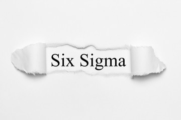 Six Sigma on white torn paper