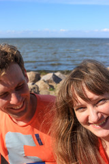 A couple of lovers sitting on boulders by the sea
