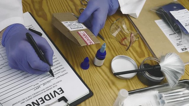 Police expert filled form with evidence bag in crime lab