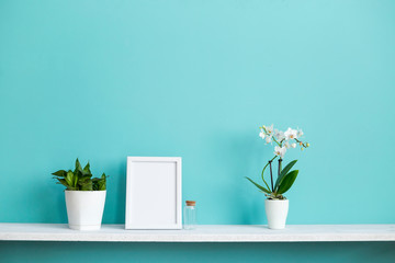 Modern room decoration with Picture frame mockup. White shelf against pastel turquoise wall with...