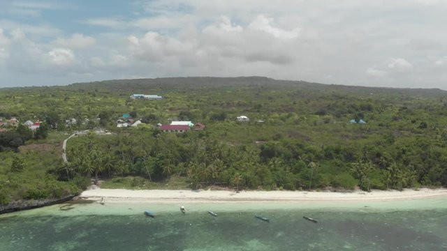 Aerial: Flying over tropical beach turquoise water coral reef , Tomia island Wakatobi National Park Indonesia Maldives Polynesia white sand beach. Native cinelike D-log color profile
