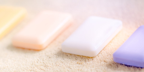 Four bars of soap on a pale brown towel.