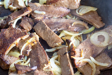 gebratenes Fleisch mit Zwiebeln in einer Pfanne