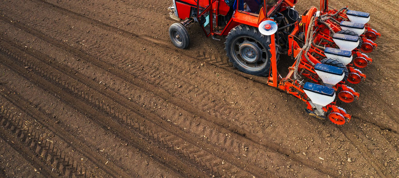 Fototapeta Aerial view of tractor with mounted seeder performing direct seeding