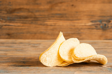 Crispy potato chips in wooden bowl. Salted potato chips.