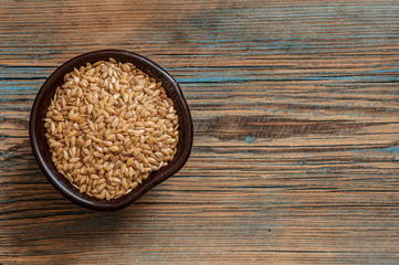 Flax seeds in a bowl with a spoon on a wood vintage background. Flax seeds are rich with fatty acid, omega 3 and fiber