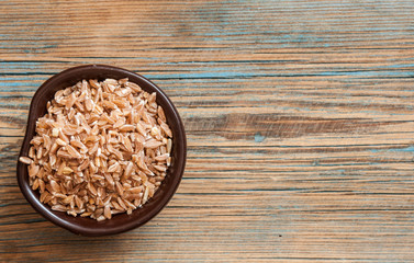 Bowl with Spelt (close-up shot) on wooden background