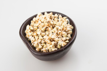 Sprouts of green buckwheat in a bowl. Macro shot. Raw buckwheat. Useful food from buckwheat sprouts for vegetarian food.