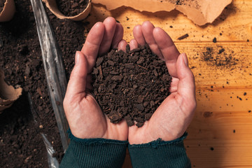 Gardener holding soil in cupped hands, top view