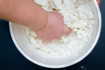 Mixing in a bowl of ingredients butter, cottage cheese and flour for the preparation of cookies