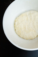 Raw mixed dough lies in a mixing bowl