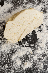 Raw cut dough lies on the table with flour before cooking cottage cheese cookies