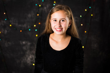 Portrait of cheerful teenage girl on festive background