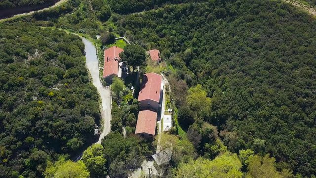 drone view flying over houses on Mount Tek Tek, path surrounded by beautiful forest, green trees, sunny day, bird look from above, slow motion, in Suayip ancient city of Sanlıurfa Province, Turkey