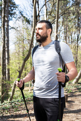 Man walking through a forest wearing a backpack.