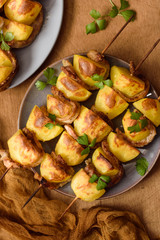 Skewers of potato and bacon in a rustic style, top view on two plates
