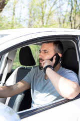 Man talking at mobile phone while driving a car.