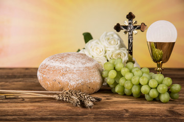 Holy communion a golden chalice with grapes and bread wafers 