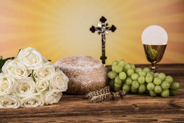 Holy communion a golden chalice with grapes and bread wafers 