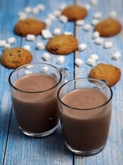 Mugs of hot cocoa with marshmallows and chocolate cookies