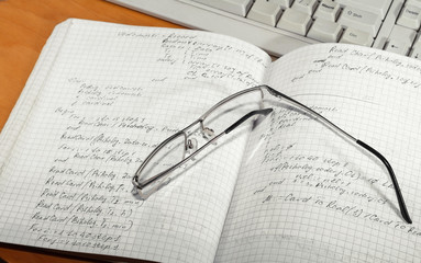 Notebook and glasses and keyboard