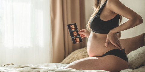 Pregnant woman holding ultrasound image. Concept of pregnancy, health care, gynecology, medicine....