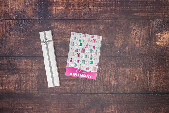 Birthday card with present on wooden background 