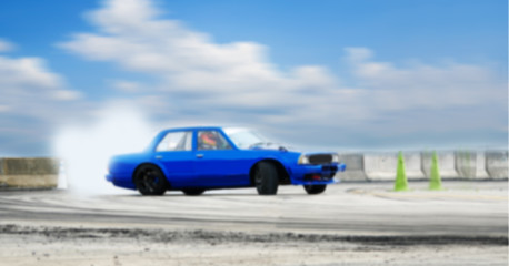 Fototapeta na wymiar Abstract blurred old car drifting, Sport car wheel drifting and smoking on blurred background. Motorsport concept.