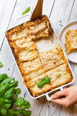 Homemade baked lasagna emiliane made from traditional meat ragù cooked for 4 hours, béchamel sauce, flat pasta. Served in a casserole  and cut into single-serving square portions. Top view. 