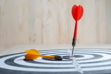 Winner Red dart arrow hit the center target of dartboard and yellow arrow loser metaphor marketing competition concept