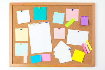 Cork board with several colorful blank notes with pins