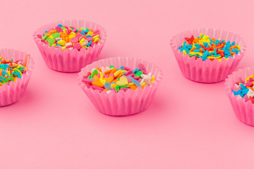 Sugar sprinkles, decoration for cake and ice-cream and cookies on pink background