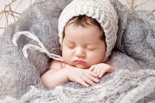 Sweet newborn baby sleeping.  Lovely newborn  2 weeks old lying in the cocon. Close up picture