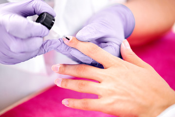 Obraz na płótnie Canvas Applying of nail a polisher on the hand nails