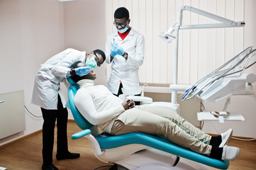 African american man patient in dental chair. Dentist office and doctor practice concept....