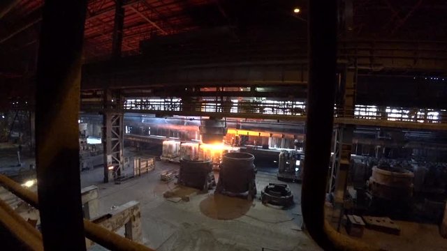 Casting liquid steel into molds In A Bof Converter at metallurgical plant.