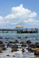Sala and Wooden walkway that leading to the sea from the beach with big white cloud in background and stone in the sea in summer in Koh Mak Island at Trat, Thailand.