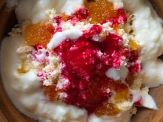 Close view on a bowl with cottage cheese, yogurt, raspberry mash and honey