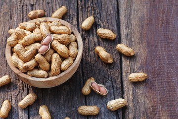 Peanut, snack, in wood bowl on classic wooden table background