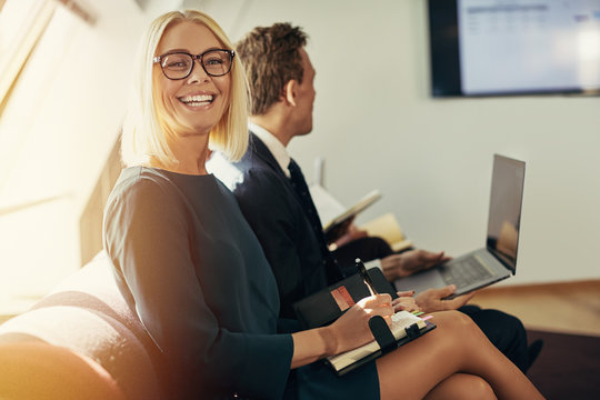 Smiling businesswoman writing in an organizer during an office p
