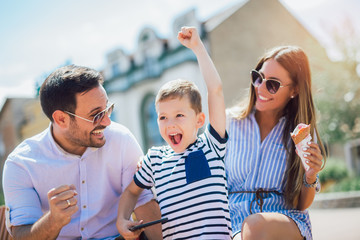 Smiling parents and little boy with tablet pc outdoor